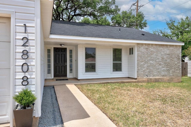 12808 Silver Creek Dr, Austin, TX 78727 - property entrance with a lawn, brick siding, and roof with shingles