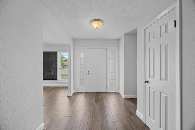 12808 Silver Creek Dr, Austin, TX 78727 - foyer entrance featuring a textured ceiling, dark wood-type flooring, and a textured wall