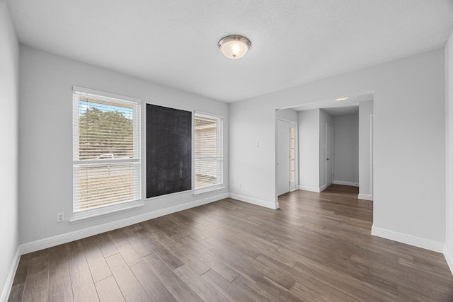 12808 Silver Creek Dr, Austin, TX 78727 - empty room with baseboards and dark wood-style flooring