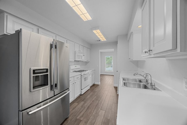 12808 Silver Creek Dr, Austin, TX 78727 - kitchen featuring white appliances, white cabinets, wood finished floors, and light countertops