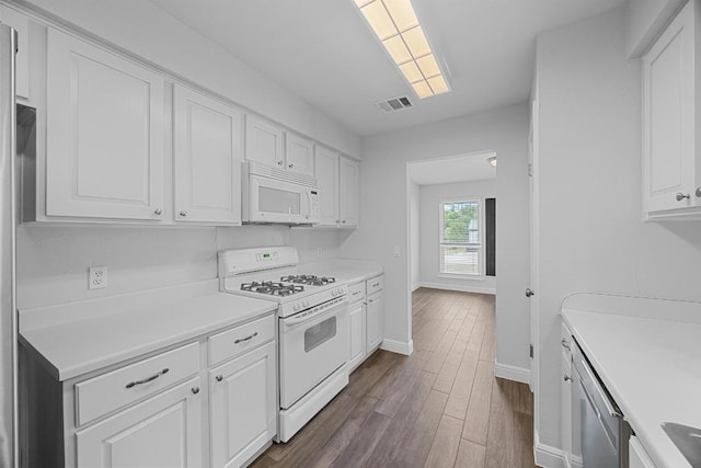 12808 Silver Creek Dr, Austin, TX 78727 - kitchen with white appliances, white cabinetry, dark wood-style floors, and light countertops