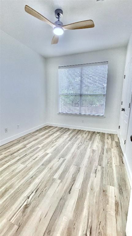 313 El Socorro Ln, Austin, TX 78732 - spare room with a ceiling fan, baseboards, and wood finished floors