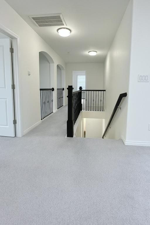 313 El Socorro Ln, Austin, TX 78732 - hall featuring carpet flooring, baseboards, an upstairs landing, and visible vents