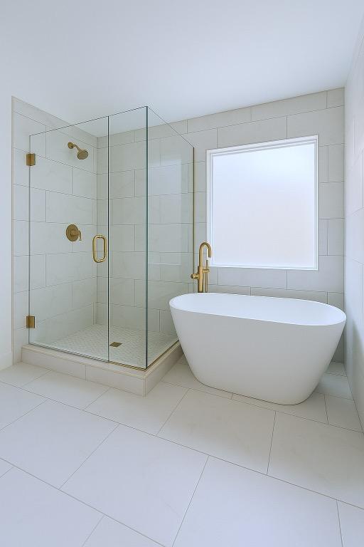 313 El Socorro Ln, Austin, TX 78732 - bathroom featuring a freestanding bath, tile patterned floors, a stall shower, and tile walls