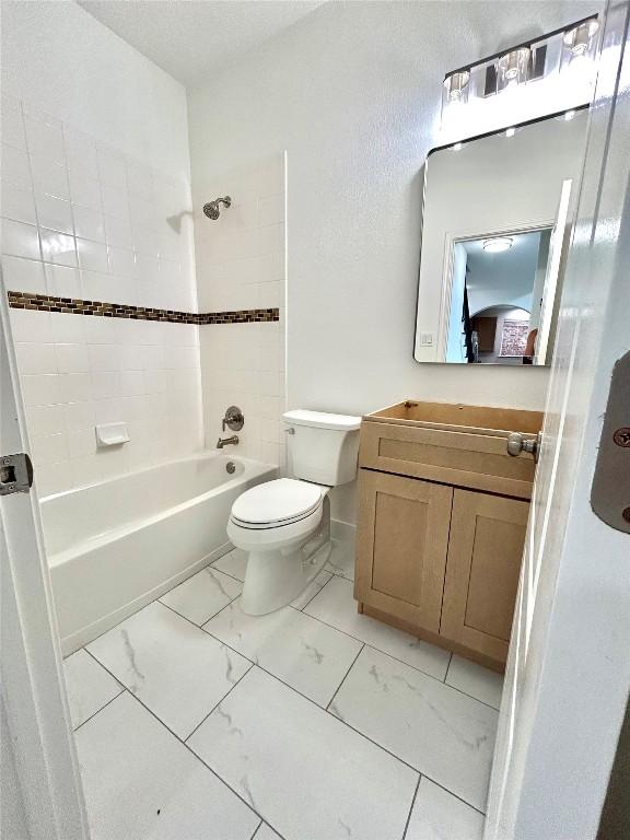 313 El Socorro Ln, Austin, TX 78732 - full bathroom featuring washtub / shower combination, vanity, toilet, and marble finish floor