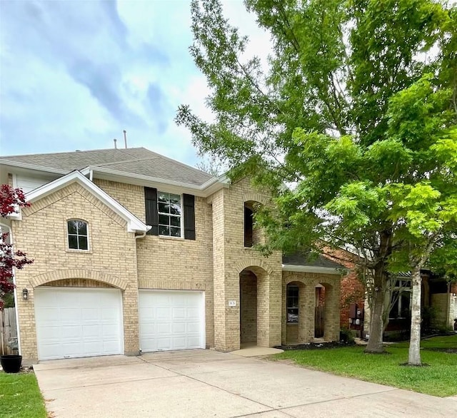 313 El Socorro Ln, Austin, TX 78732 - view of front of home featuring driveway, an attached garage, a shingled roof, brick siding, and a front lawn