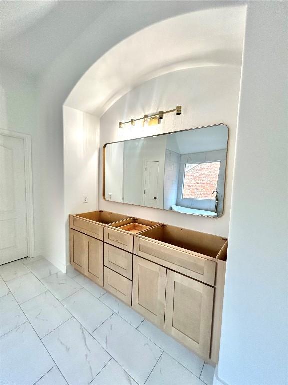 313 El Socorro Ln, Austin, TX 78732 - bathroom featuring vaulted ceiling, marble finish floor, and vanity