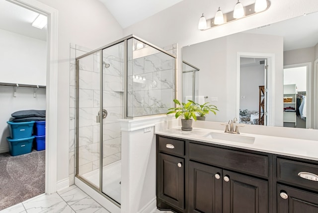 full bathroom featuring vanity, a stall shower, marble finish floor, a walk in closet, and baseboards