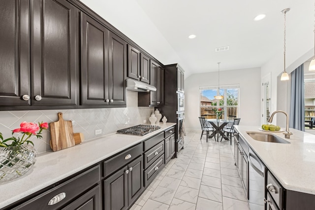 kitchen with a sink, decorative backsplash, stainless steel appliances, visible vents, and pendant lighting