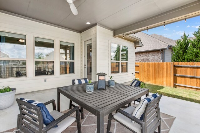view of patio with outdoor dining area, ceiling fan, and fence