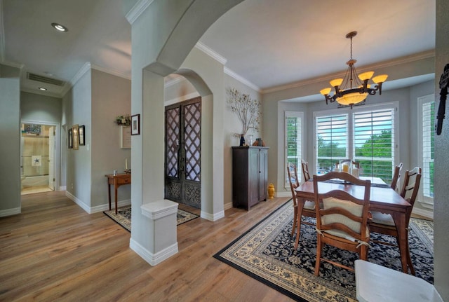 106 Clubhouse Dr, Lakeway, TX 78734 - dining room featuring arched walkways, a chandelier, light wood-style floors, crown molding, and recessed lighting