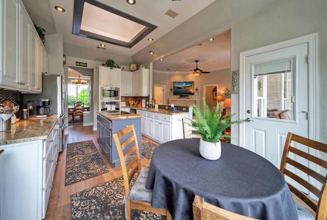 106 Clubhouse Dr, Lakeway, TX 78734 - dining room featuring a raised ceiling, recessed lighting, light wood finished floors, and a ceiling fan