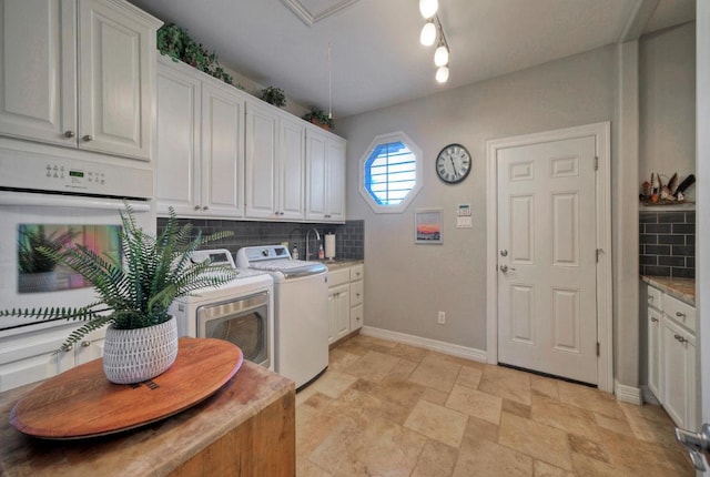 106 Clubhouse Dr, Lakeway, TX 78734 - laundry room with washer and dryer, light stone finish flooring, and cabinet space