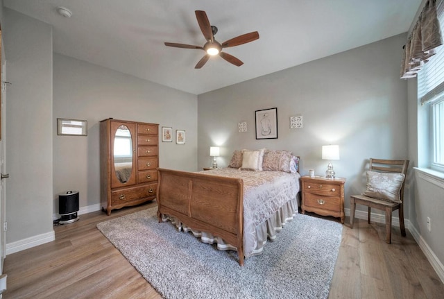 bedroom featuring ceiling fan, light wood-style flooring, and baseboards