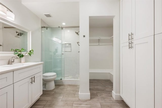 7310 Broken Arrow Ln, Austin, TX 78745 - full bathroom with toilet, visible vents, a shower stall, and vanity