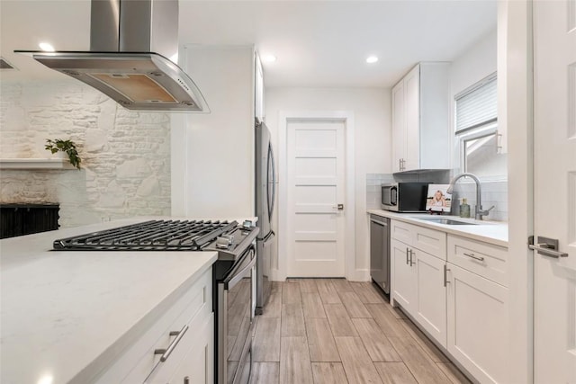 7310 Broken Arrow Ln, Austin, TX 78745 - kitchen with stainless steel appliances, island range hood, backsplash, light countertops, and white cabinets