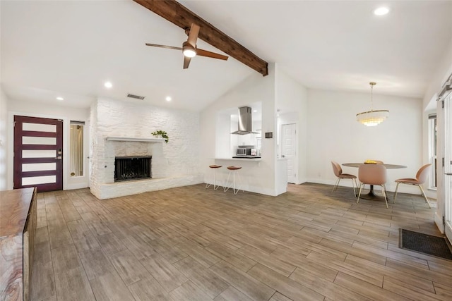 7310 Broken Arrow Ln, Austin, TX 78745 - living room with recessed lighting, a fireplace, vaulted ceiling with beams, visible vents, and wood finished floors