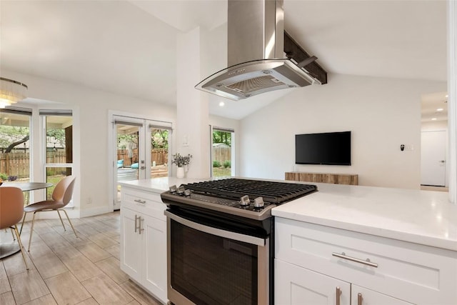 7310 Broken Arrow Ln, Austin, TX 78745 - kitchen with white cabinets, lofted ceiling with beams, island range hood, light countertops, and stainless steel gas range oven