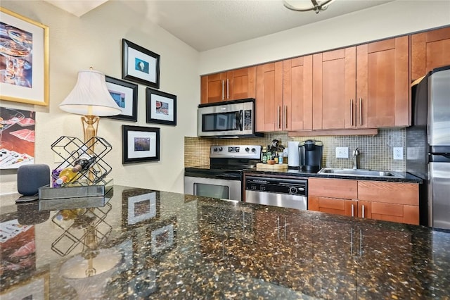 7685 Northcross Dr Unit 304, Austin, TX 78757 - kitchen featuring appliances with stainless steel finishes, decorative backsplash, brown cabinets, and dark stone counters