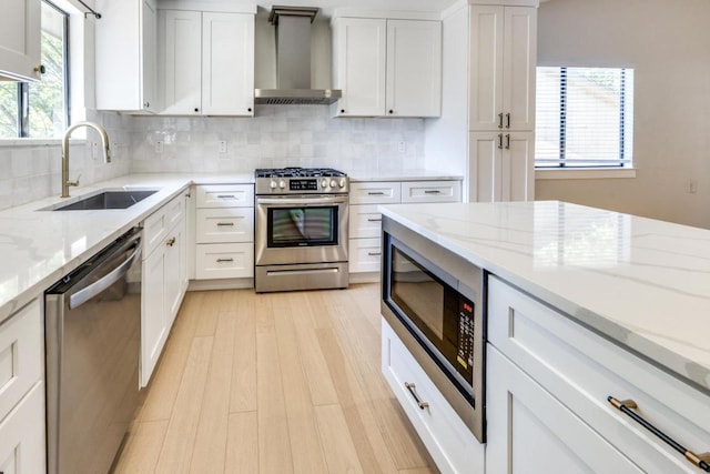 7901 Keswick Dr, Austin, TX 78745 - kitchen with appliances with stainless steel finishes, wall chimney exhaust hood, white cabinets, and decorative backsplash