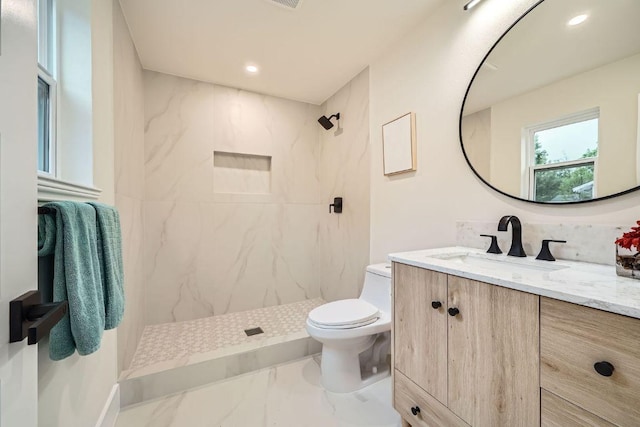 full bathroom featuring toilet, a marble finish shower, marble finish floor, and vanity