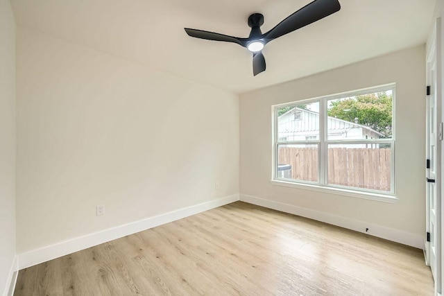 empty room with baseboards, ceiling fan, and wood finished floors