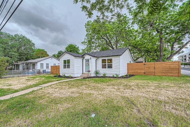 view of front facade with a gate, fence, and a front yard