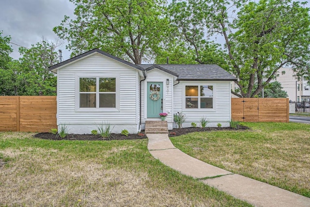 view of front of house featuring fence and a front yard
