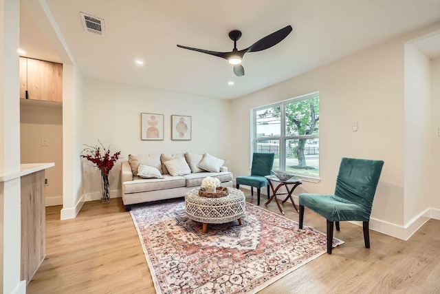 living area with light wood-style floors, baseboards, a ceiling fan, and recessed lighting