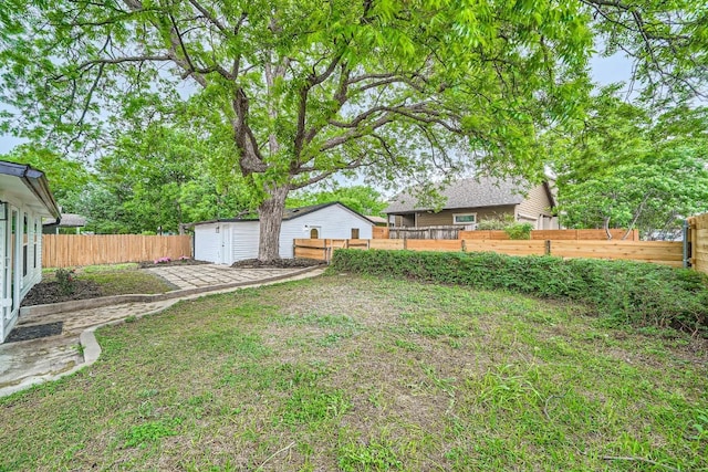 view of yard featuring an outdoor structure, a fenced backyard, and a storage unit
