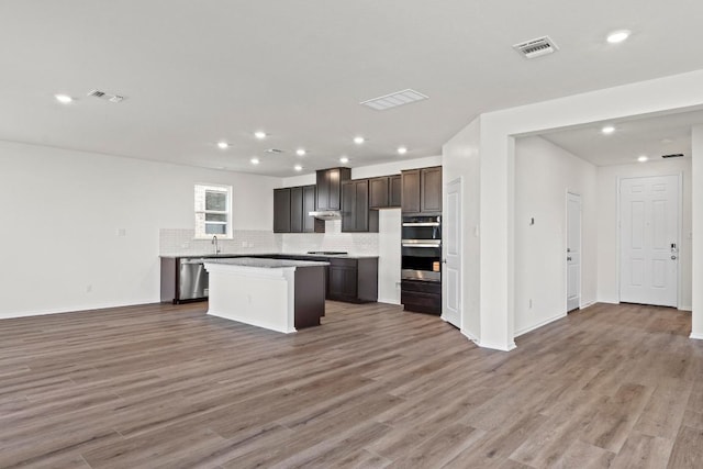 3756 Liberi Ln, Round Rock, TX 78665 - kitchen featuring stainless steel appliances, open floor plan, wood finished floors, tasteful backsplash, and recessed lighting