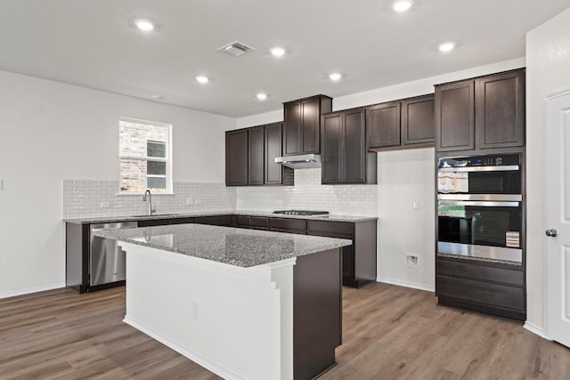 3756 Liberi Ln, Round Rock, TX 78665 - kitchen with stainless steel appliances, a sink, dark brown cabinets, light wood-type flooring, and recessed lighting