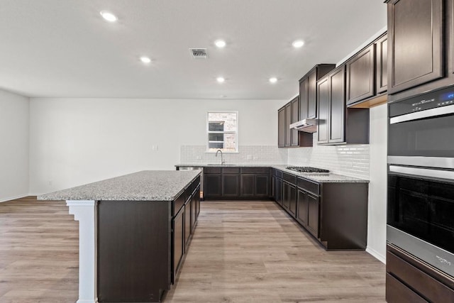 3756 Liberi Ln, Round Rock, TX 78665 - kitchen featuring a sink, a kitchen island, double oven, dark brown cabinetry, and recessed lighting
