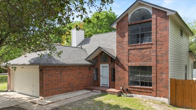 traditional-style house with a chimney, brick siding, fence, roof with shingles, and an attached garage