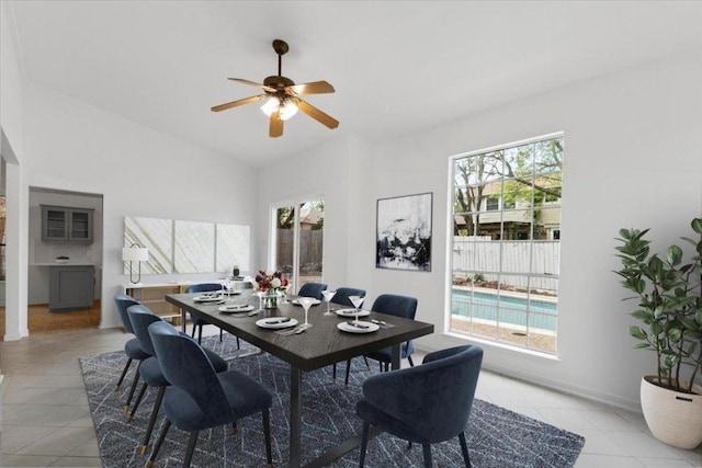 dining space with ceiling fan, light tile patterned flooring, and lofted ceiling