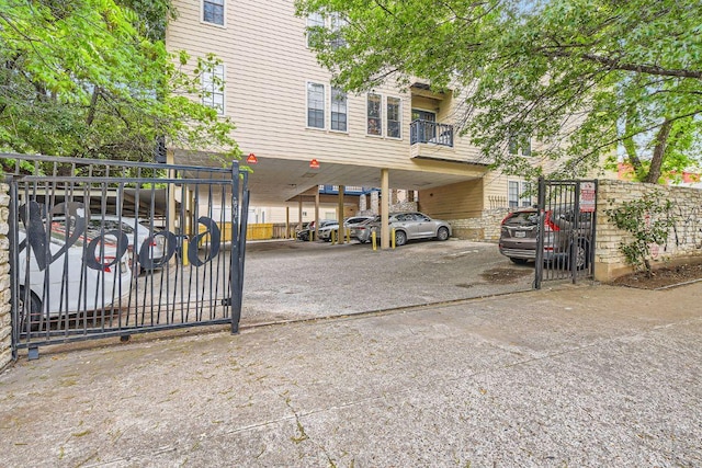 view of vehicle parking with a gate and fence private yard