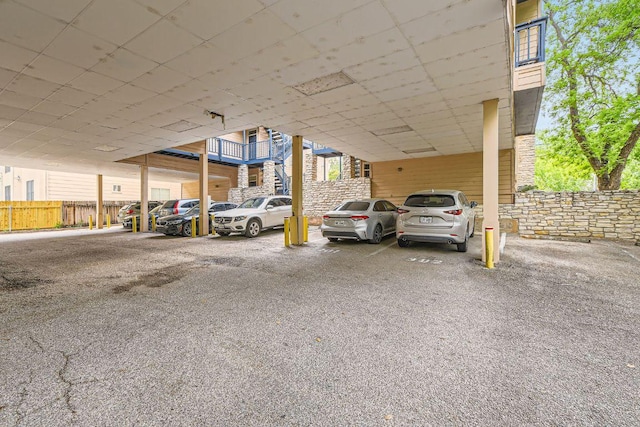 covered parking lot featuring fence
