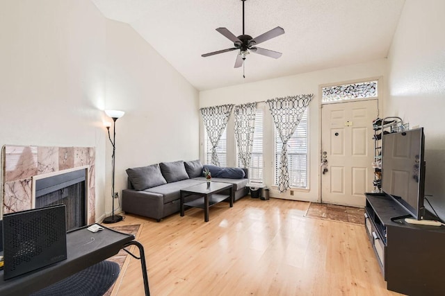 living room featuring light wood-style flooring, ceiling fan, and a wealth of natural light