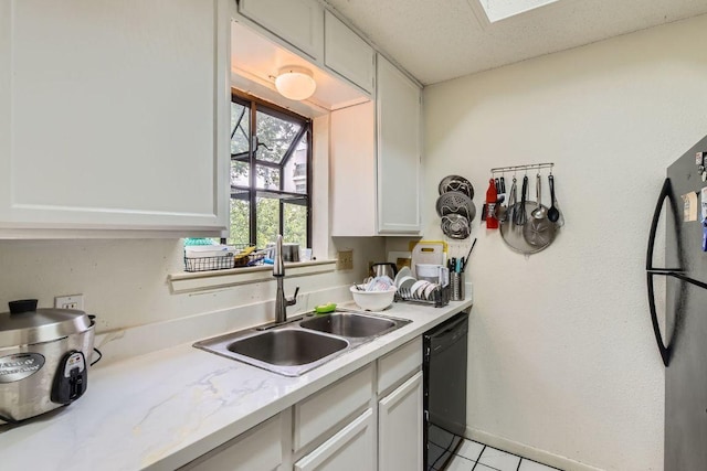 kitchen featuring light tile patterned floors, white cabinets, a sink, light countertops, and black dishwasher