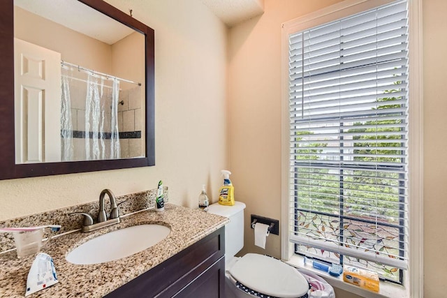 bathroom with toilet, a shower with curtain, and vanity