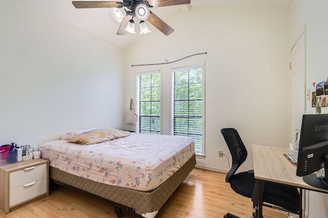 bedroom with baseboards, light wood-type flooring, a ceiling fan, and lofted ceiling