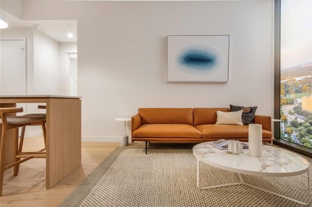 living room with recessed lighting, light wood-style flooring, and baseboards