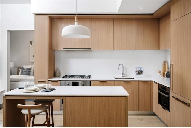 kitchen featuring a sink, light countertops, oven, gas stovetop, and modern cabinets