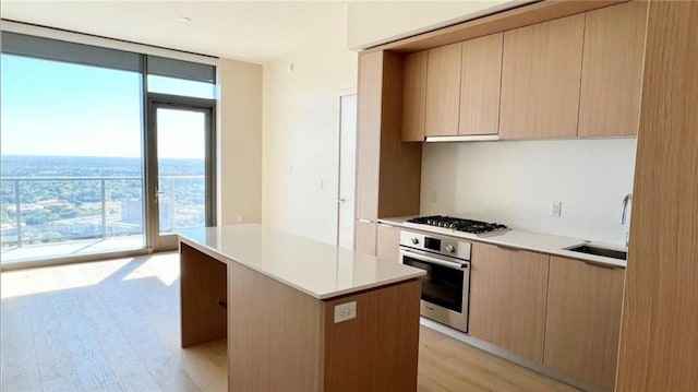 kitchen featuring expansive windows, gas cooktop, modern cabinets, and stainless steel oven