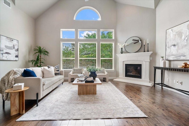 4211 Front Range Ln, Austin, TX 78732 - living room featuring a glass covered fireplace, visible vents, hardwood / wood-style flooring, and high vaulted ceiling