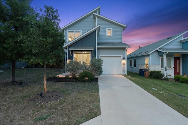 view of front facade featuring a yard, board and batten siding, an attached garage, and driveway