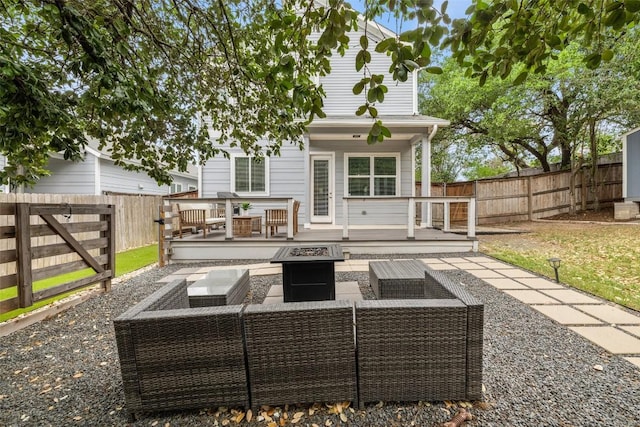 back of property featuring a fenced backyard, an outdoor living space with a fire pit, and a wooden deck