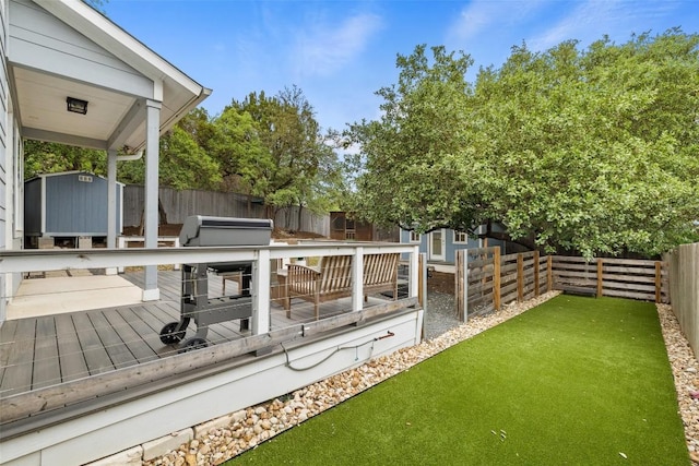 view of yard featuring a fenced backyard, an outbuilding, a storage shed, and a deck