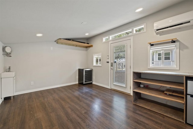 foyer featuring wood finished floors, recessed lighting, baseboards, and a wall unit AC