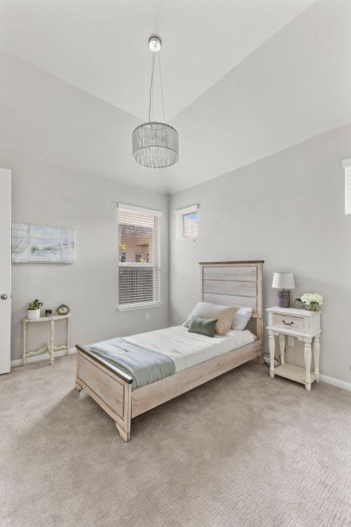 1401 Clearwing Cir, Georgetown, TX 78626 - bedroom with carpet flooring, a chandelier, and baseboards